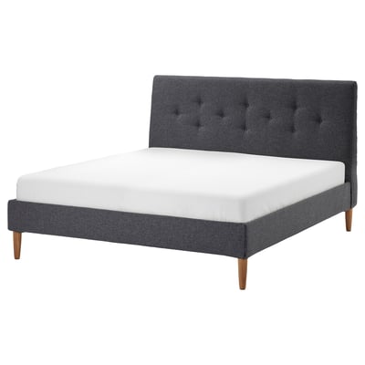 Dark grey IDANÄS bed frame with tufted headboard, wooden legs, and white mattress.