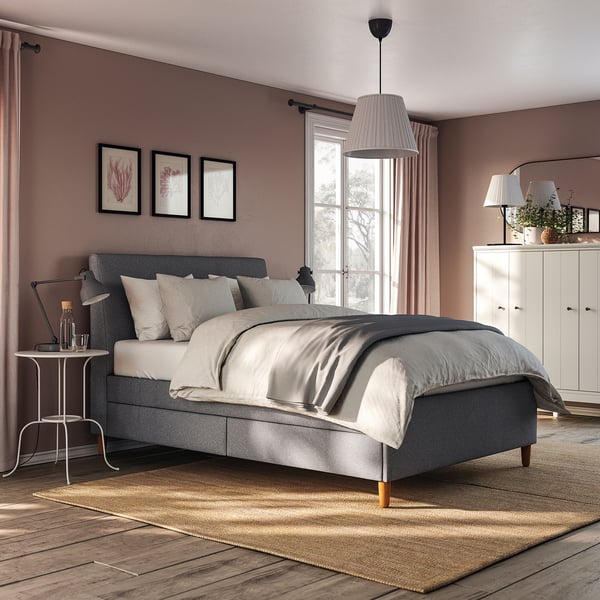 Modern grey upholstered bed with sloped headboard, wooden legs, and built-in storage drawers.