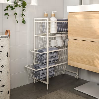 White JONAXEL bathroom storage with wire baskets, holding towels and toiletries, next to vanity. Made of steel, suitable for humid areas.