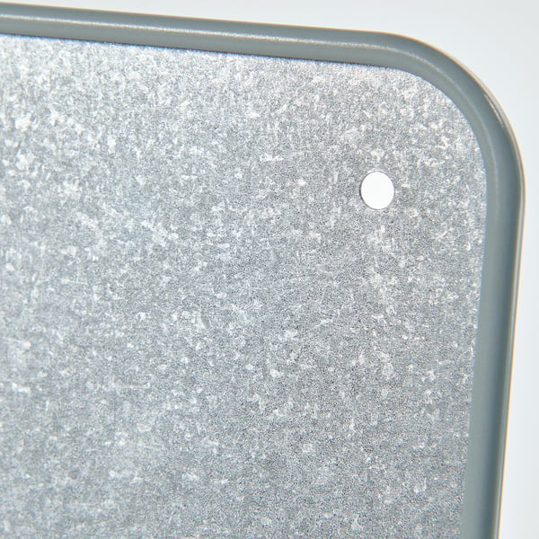 Metal sheet with small raised dots and a central round hole, framed by a green border.