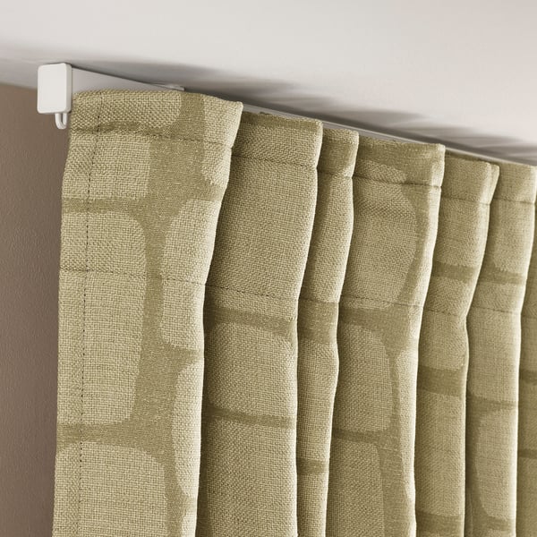 Green textured curtains with white rod and back tab for hanging.