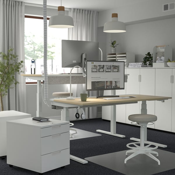 Modern home office setup with MITTZON white sit/stand desk, ergonomic stool, and dual-monitor workspace.