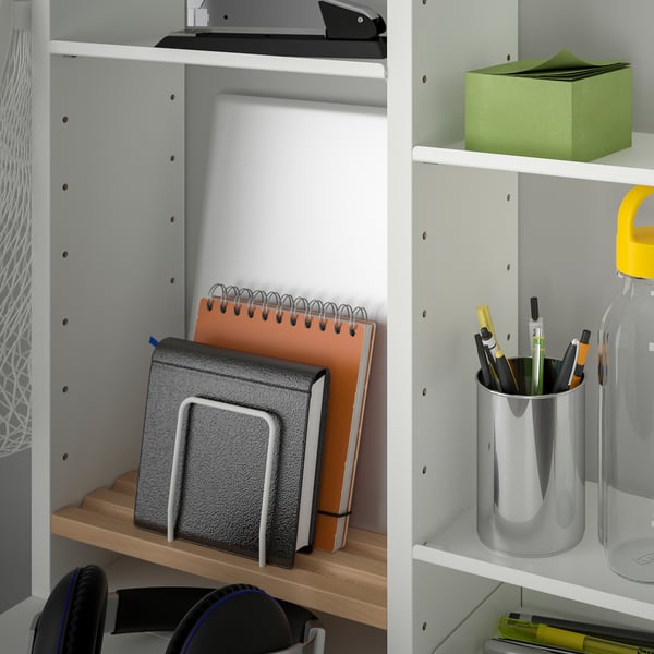 Organised shelf unit with notebooks, pens, and water bottle. Adjustable shelves and trays for efficient storage.