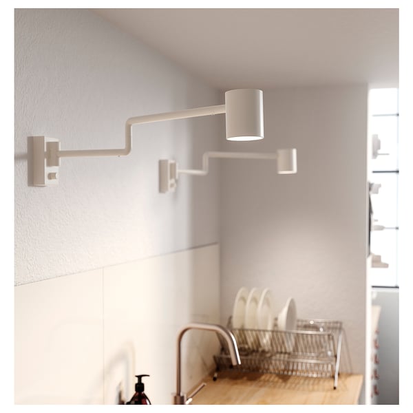 Kitchen with wall-mounted white NYMÅNE lamp, adjustable arm and dimmable light.