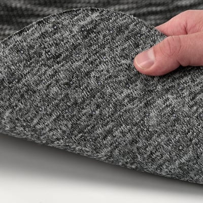 A hand pressing on a soft, textured seat pad designed for comfort and stability.