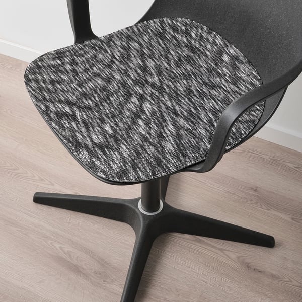Modern office chair with textured, padded seat; sturdy black base; stylish wooden floor.