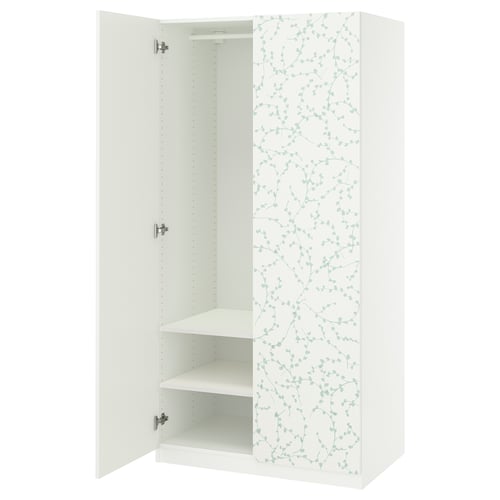 A white PAX wardrobe with green floral design, featuring open doors, shelves, and soft-close hinges.