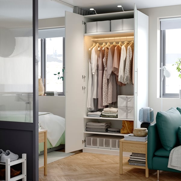 Modern bedroom wardrobe with clothes, shelves, and internal lighting. Soft-closing doors and organised storage.