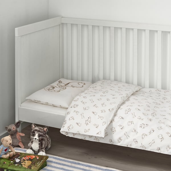 White RÖDHAKE kids bed with soft, patterned duvet cover sits in a corner. Mounted stuffed animals are visible beneath it.