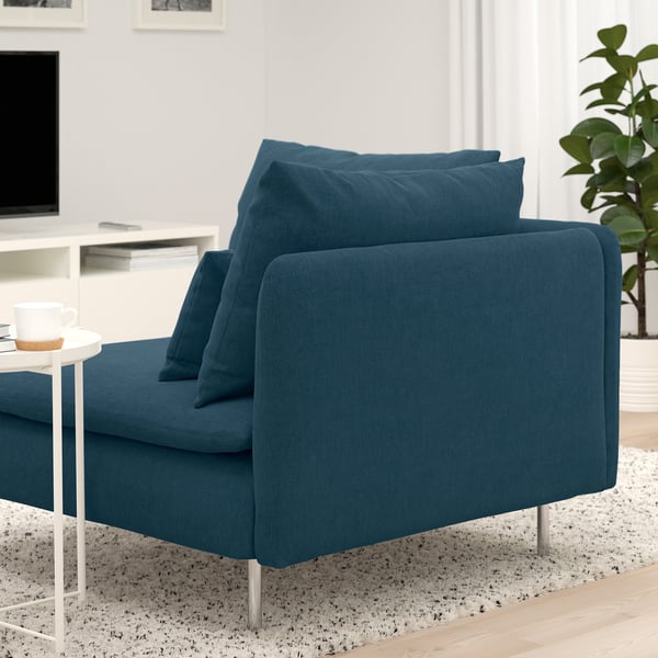 Modern teal sofa with deep cushions, metallics legs, coffee cup on side table.