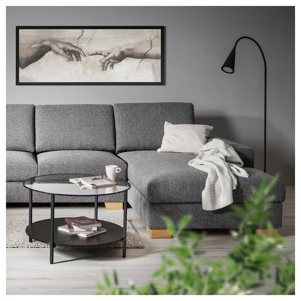 Modern living room with grey SÖRVALLEN sofa, black coffee table, and michelangelos the creation of adam art above.