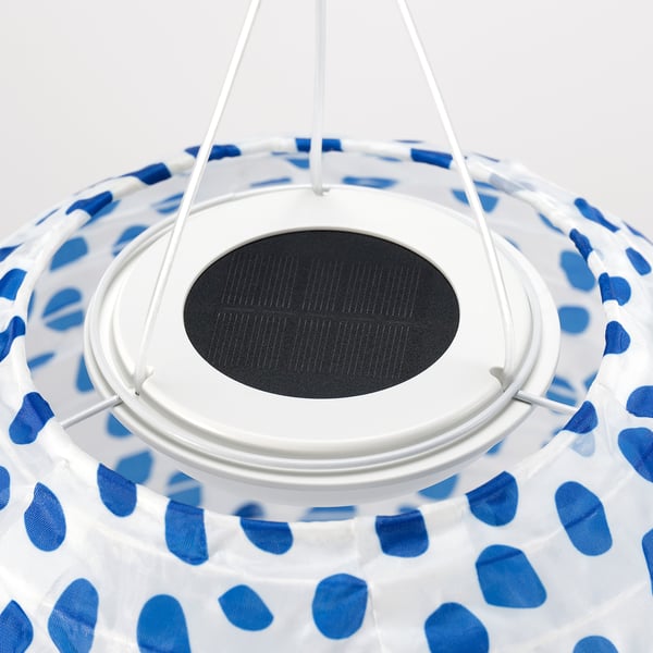 Pendant lamp with blue patterned shade. Solar panel and white support. Modern and eco-friendly design.