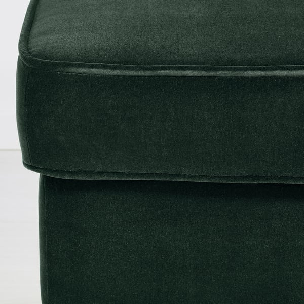 Green velvet upholstered ottoman with clean lines and elegant stitching.