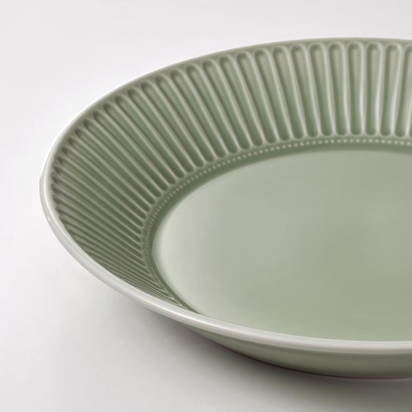 Green ribbed bowl on white.