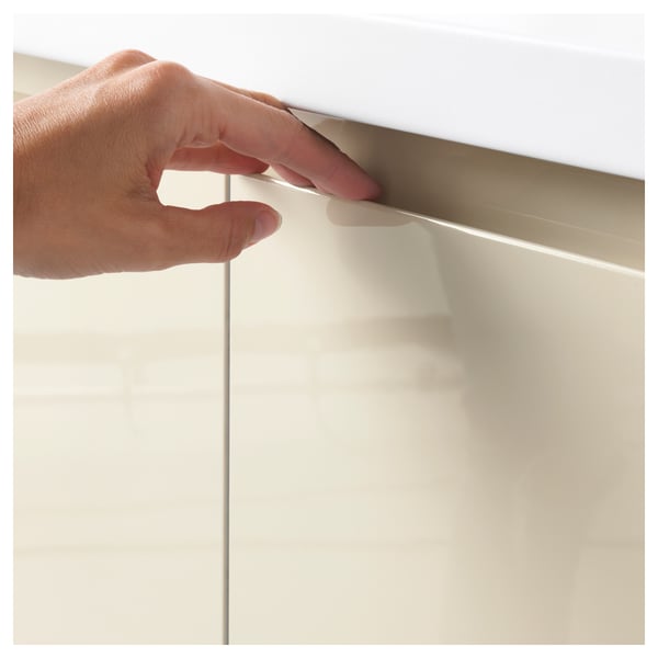 Hand opening high-gloss beige cabinet with integrated handle, showcasing its modern and easy-to-clean design.
