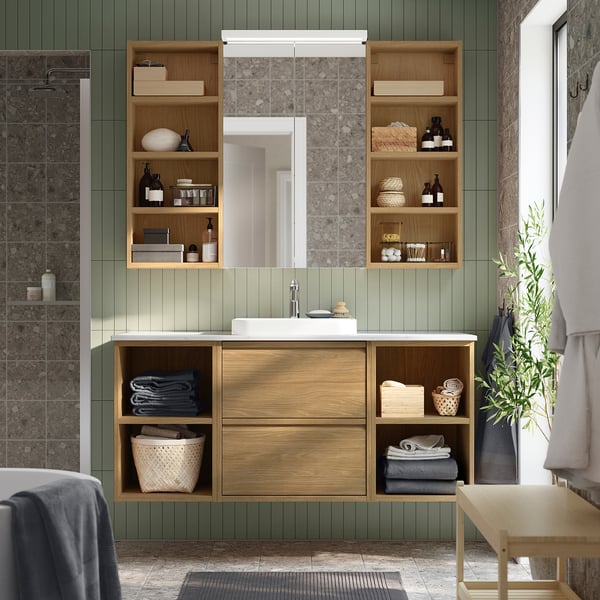 Modern bathroom setup: ÄNGSJÖN unit with oak shelves & marble basin, mirror, towels, & plant. Compact yet spacious.