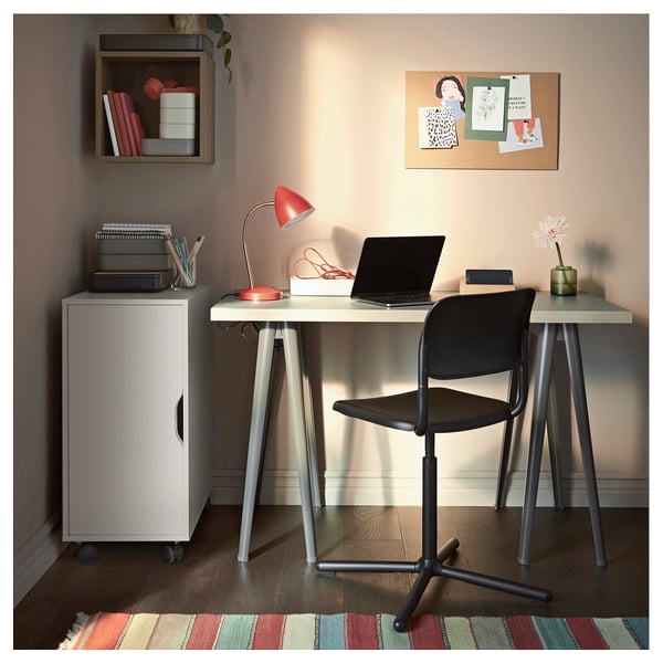 Home office setup: desk, chair, rug, lamp, laptop.