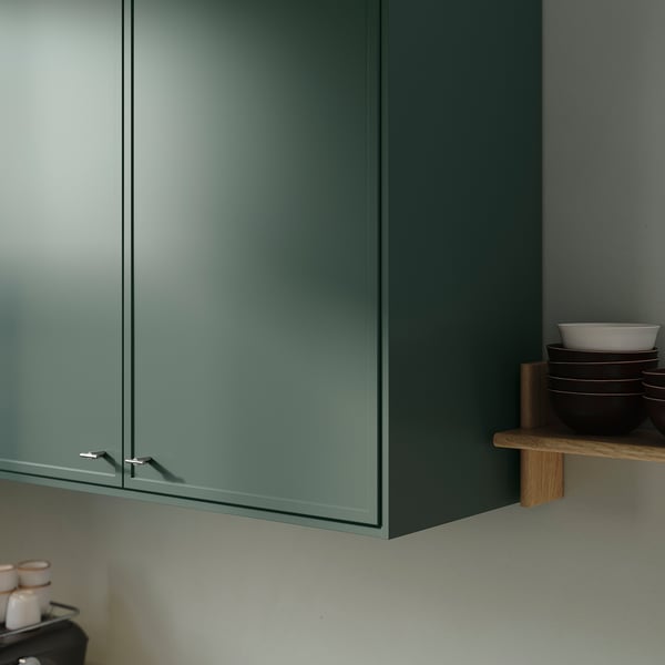 Kitchen cabinets with thin, greenish frames, left-hinged door, and stacked bowls.