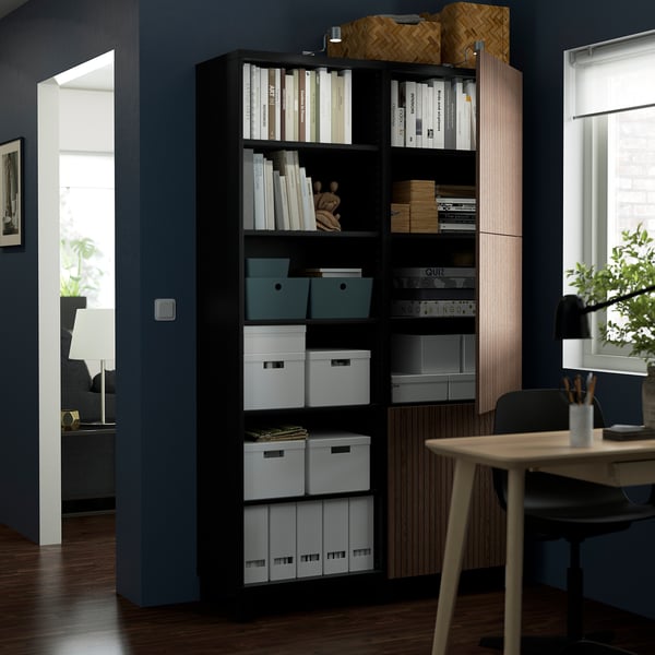 Bookshelf with adjustable shelves and both open and closed storage, displaying organised items.