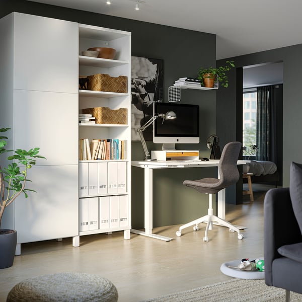 Home office with white BESTÅ storage units. Modern grey chair at desk with computer.