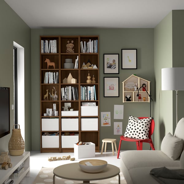 Childs room with BILLY bookcase, toys, red chair, and cozy furniture.