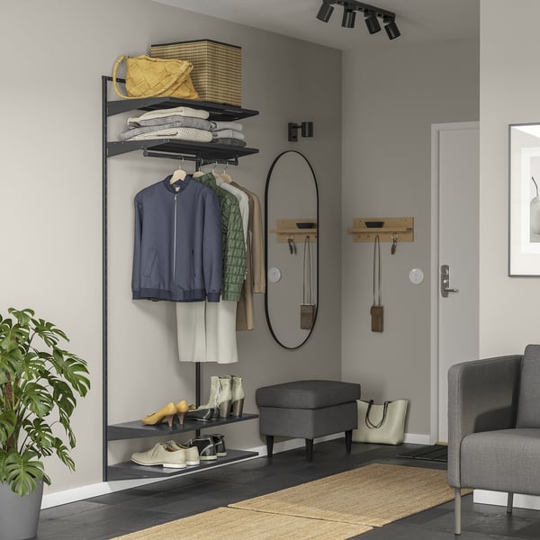 Modern grey entryway organiser with shelves and hooks for coats, boots, and bags. Includes mirror, seating, and indoor plant.