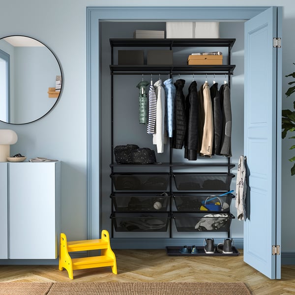 Yellow stool, black BOAXEL closet, neat clothes, blue walls.