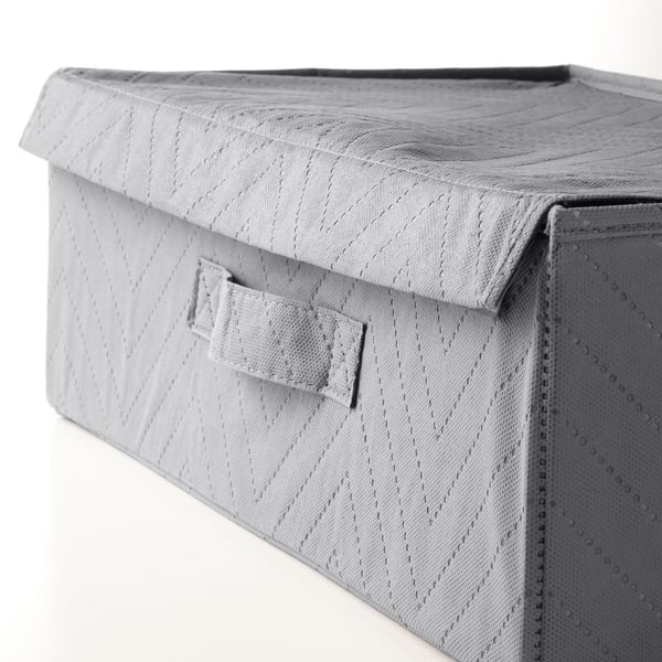 Close-up of texture on grey fabric storage bin with lid and handle.