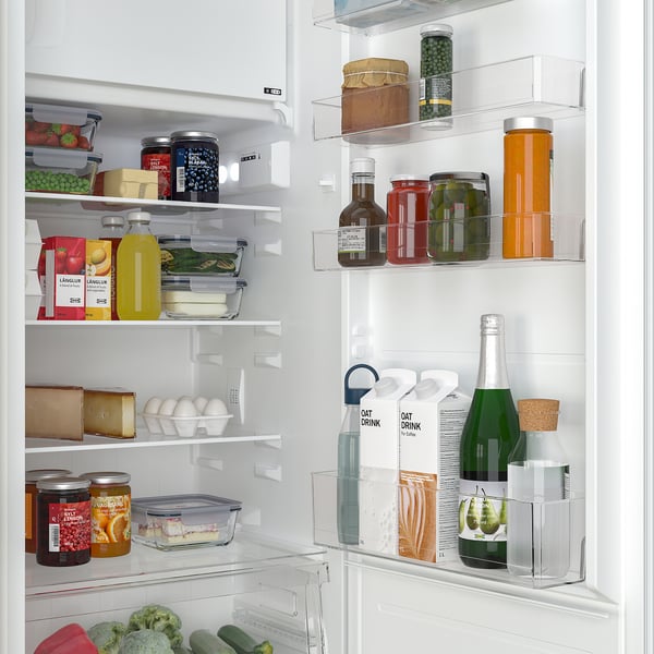 Well-organized fridge with adjustable shelves, holding fruits, vegetables, cheeses, drinks, and condiments in a neat arrangement.