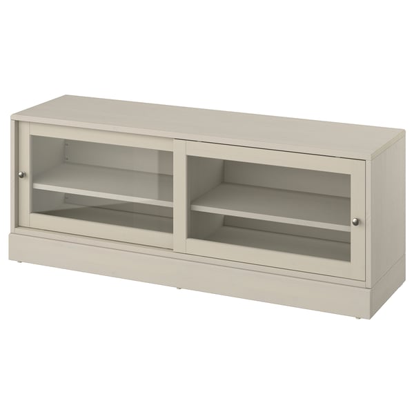 The HAVSTA tv bench, light beige, sliding glass doors and pine wood, offering a rustic yet modern design.