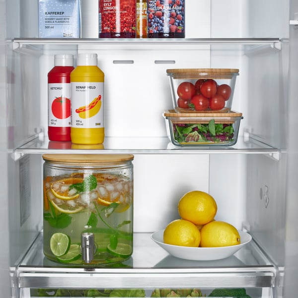 Fridge with fruit, drinks, ice, limes, mint, lemons, tomatoes.