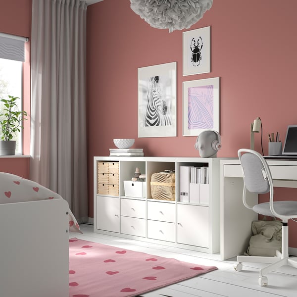 White IKEA KALLAX storage in bedroom, horizontal with drawers and open spaces, surrounded by decor.
