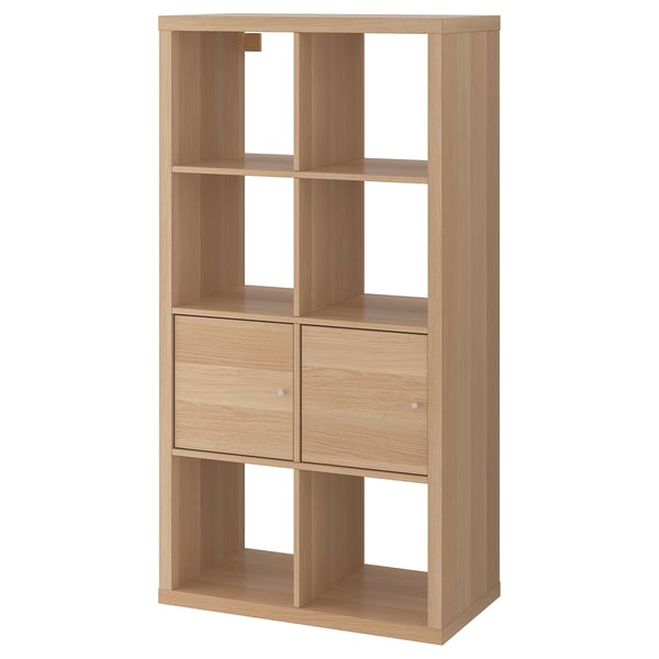 An ikea KALLAX unit, a light brown storage shelf with four cubes, two with drawers and two open shelves.