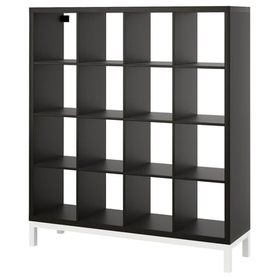 The KALLAX shelf is a black, square unit with multiple compartments, supported by white legs. Its design offers versatile storage with clean lines.