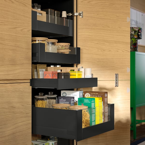 Kitchen cabinet with pull-out shelves and glass jars storing dried goods.