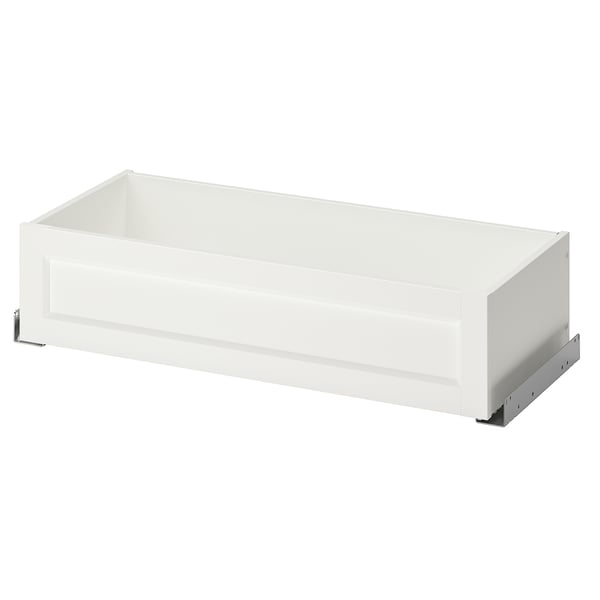 A white KOMPLEMENT wardrobe drawer with a sleek design, featuring a framed front, metal glides, and a clean, rectangular shape.