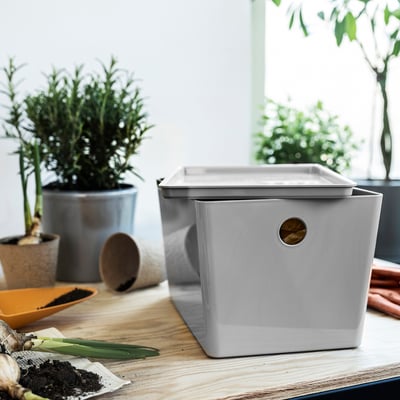 Grey KUGGIS recycling box on table with plants.