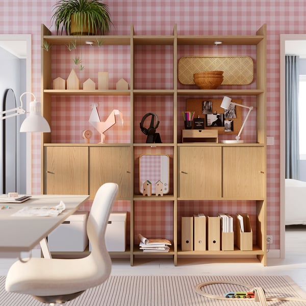 Home office with LÅDMAKARE shelves, books, decor, chair, lamp, pink walls.