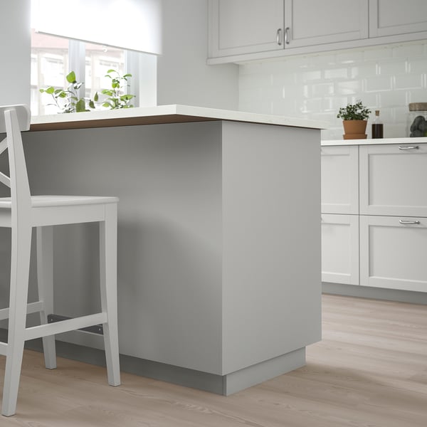 Modern grey kitchen island with white chairs, sleek design.