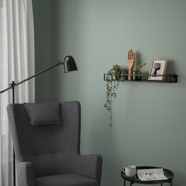 Small LINDÅSEN shelf holds plants, decor by cozy gray chair.