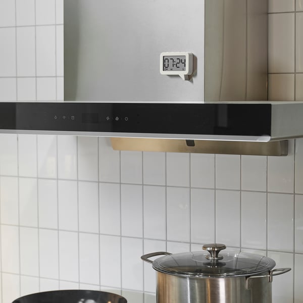 Modern kitchen with LJUNGPIPARE magnetic digital clock and large pot.