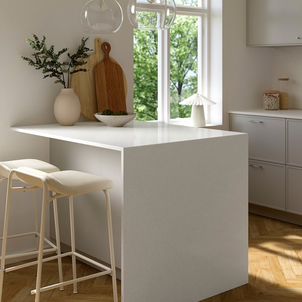 White glass composite kitchen worktop with stools, stain-resistant, minimalist decor.