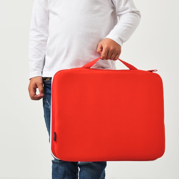 Person holding red MÅLA drawing case with handle, suitable for carrying art supplies.