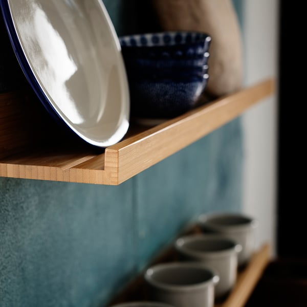 Wooden shelves holding a blue bowl and white plates; minimalist kitchen storage.