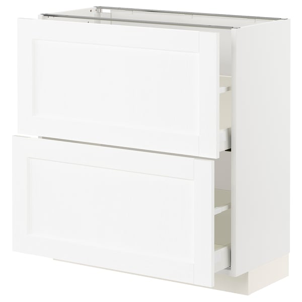 A white METOD kitchen cabinet with two drawers and two doors. The cabinet is sleek and modern with a subtle wooden texture.