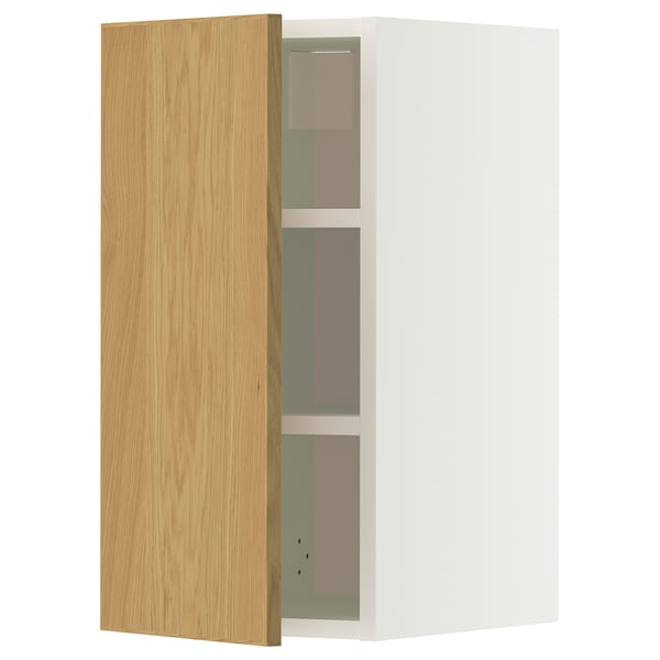 A METOD wall cabinet with a light oak door and white frame. It has three adjustable shelves and is mounted on the wall.