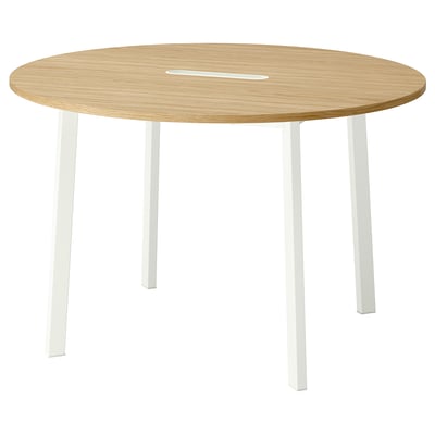 A round meeting table with light wood top and white legs. Modern, minimalist, ideal for small groups. Cable management tray.