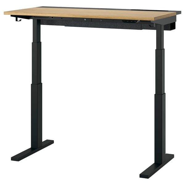 The MITTZON sit-stand desk. It is rectangular with a light wooden top and black metal legs, featuring an adjustable height mechanism.