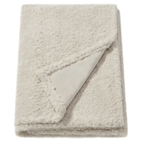 Fluffy off-white blanket, textured, folded rectangle, made from soft, recycled polyester.
