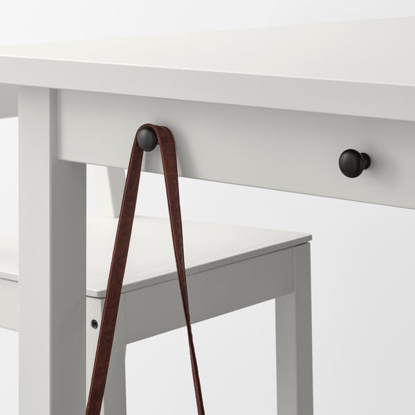 Leather strap on grey bar table with dark knobs.